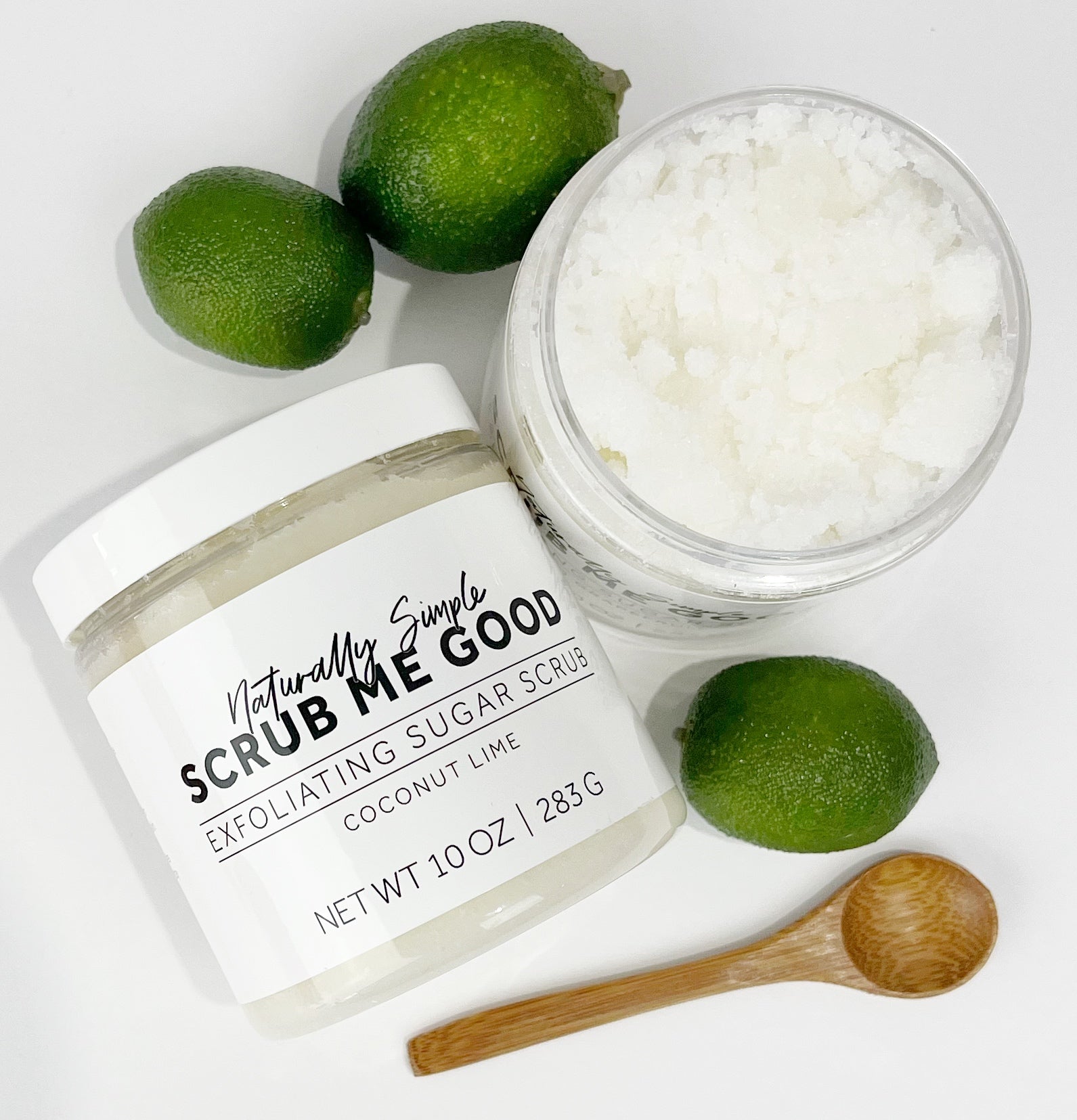 Jar of Coconut Lime Sugar Scrub handmade by Scrub Me Good, showing texture, surrounded by limes