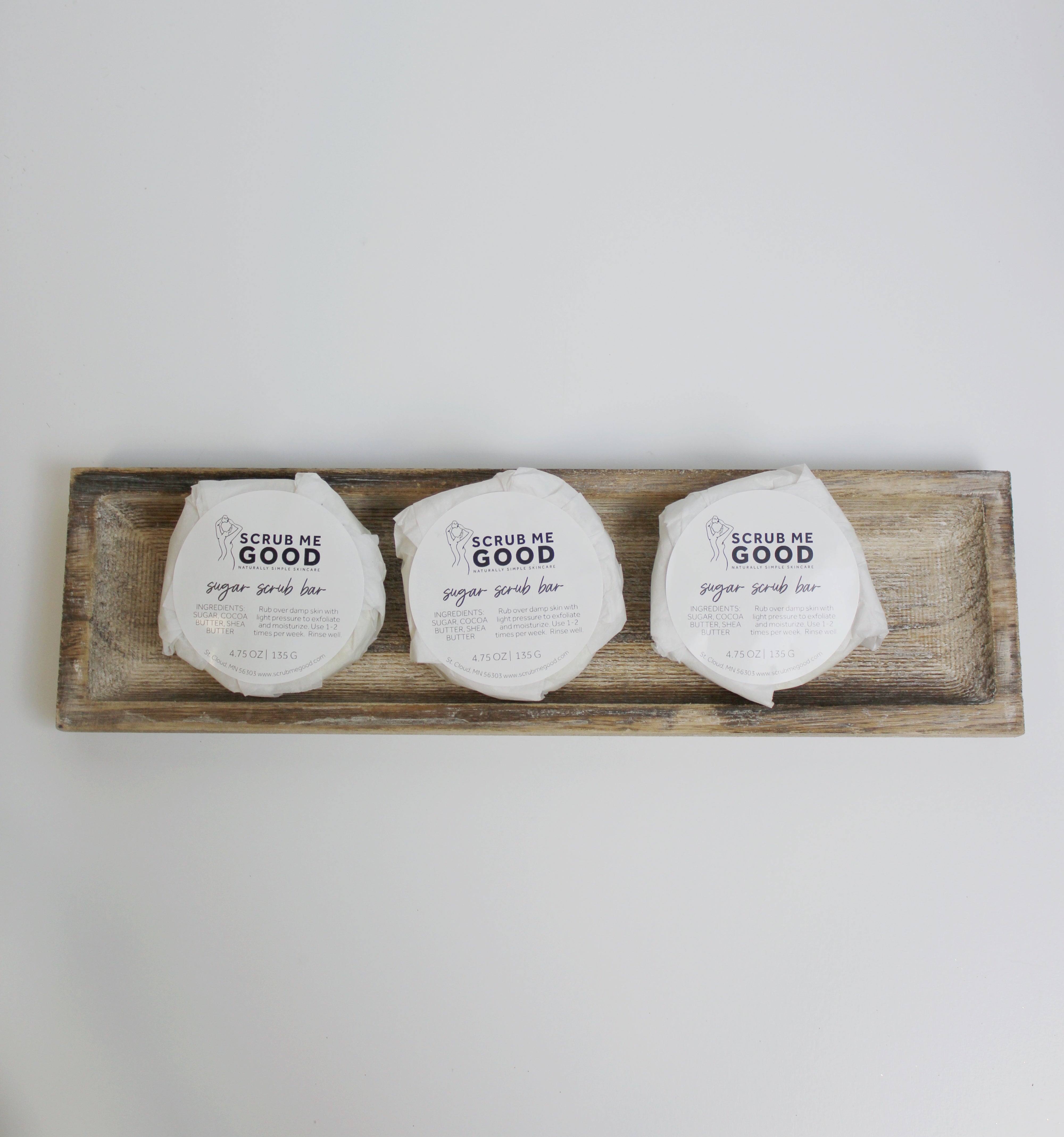 Three Sugar Scrub Bars by Scrub Me Good lined up on a wooden tray