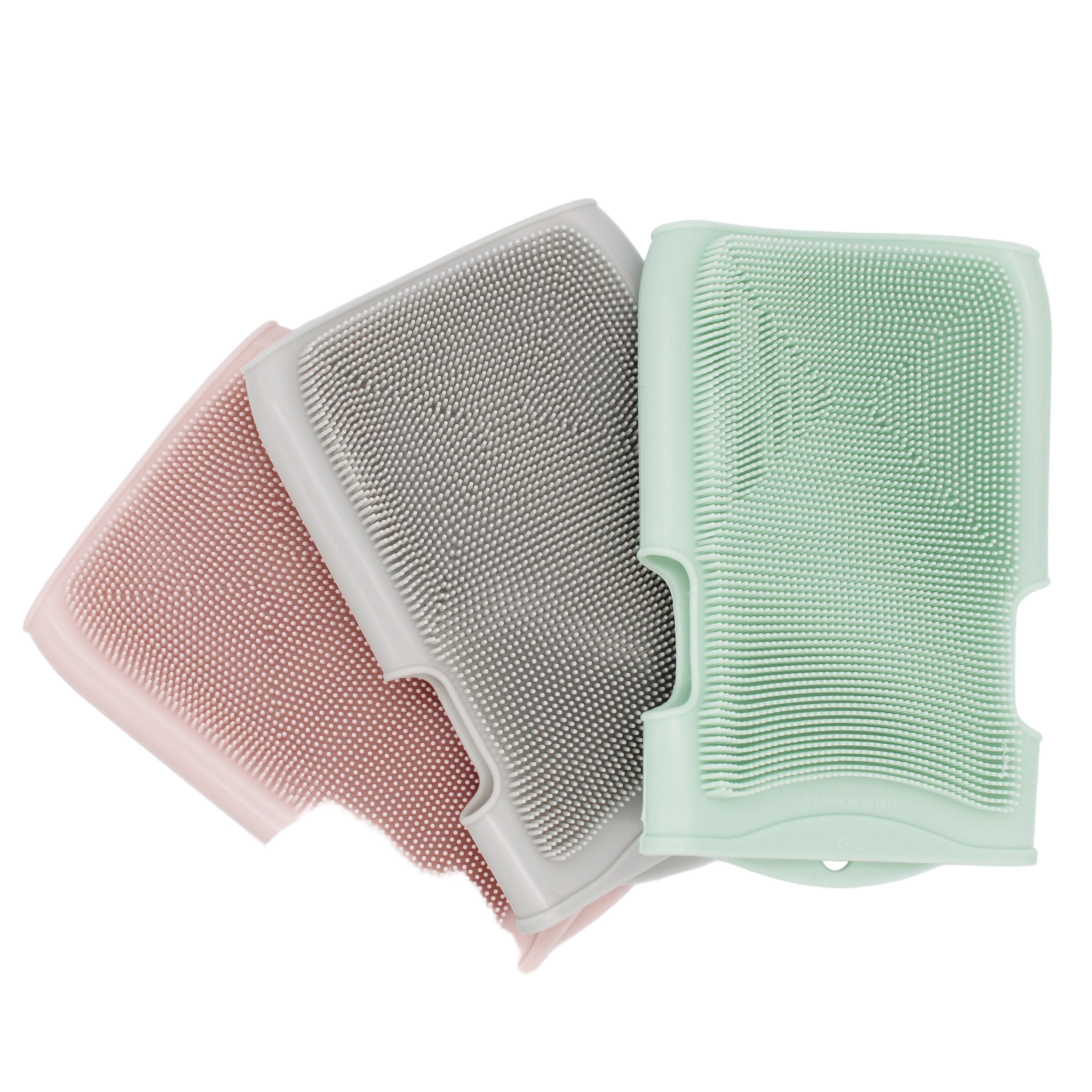 Three silicone sponges in pink, gray, and green on a white background