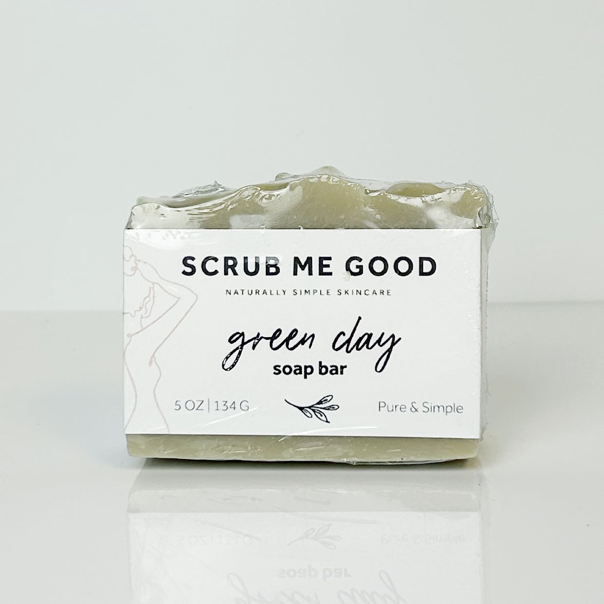 Green clay soap bar with 'Scrub Me Good' packaging on a white background
