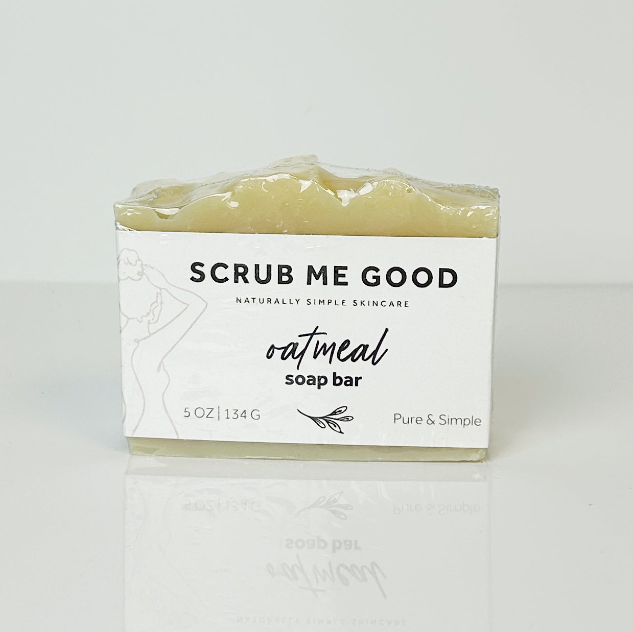 Oatmeal soap bar with 'Scrub Me Good' packaging on a white background