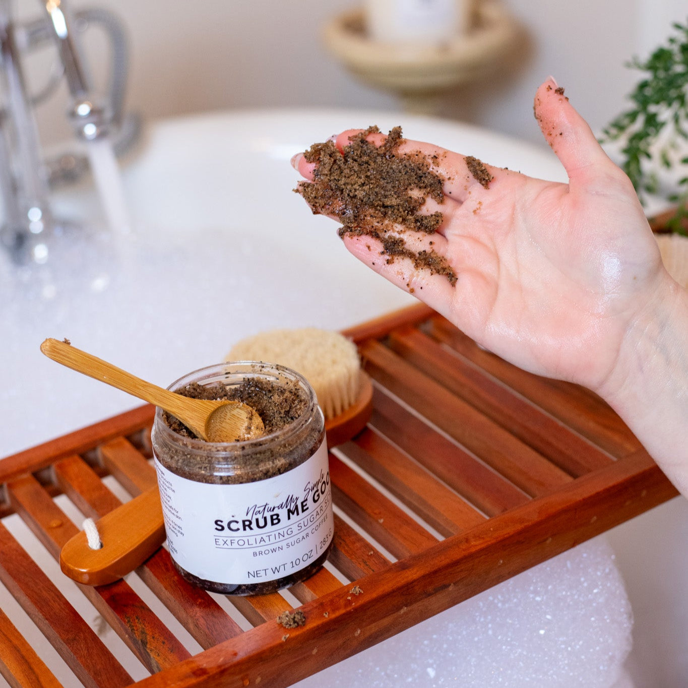woamn showing texture of brown sugar coffee sugar scrub on her hand