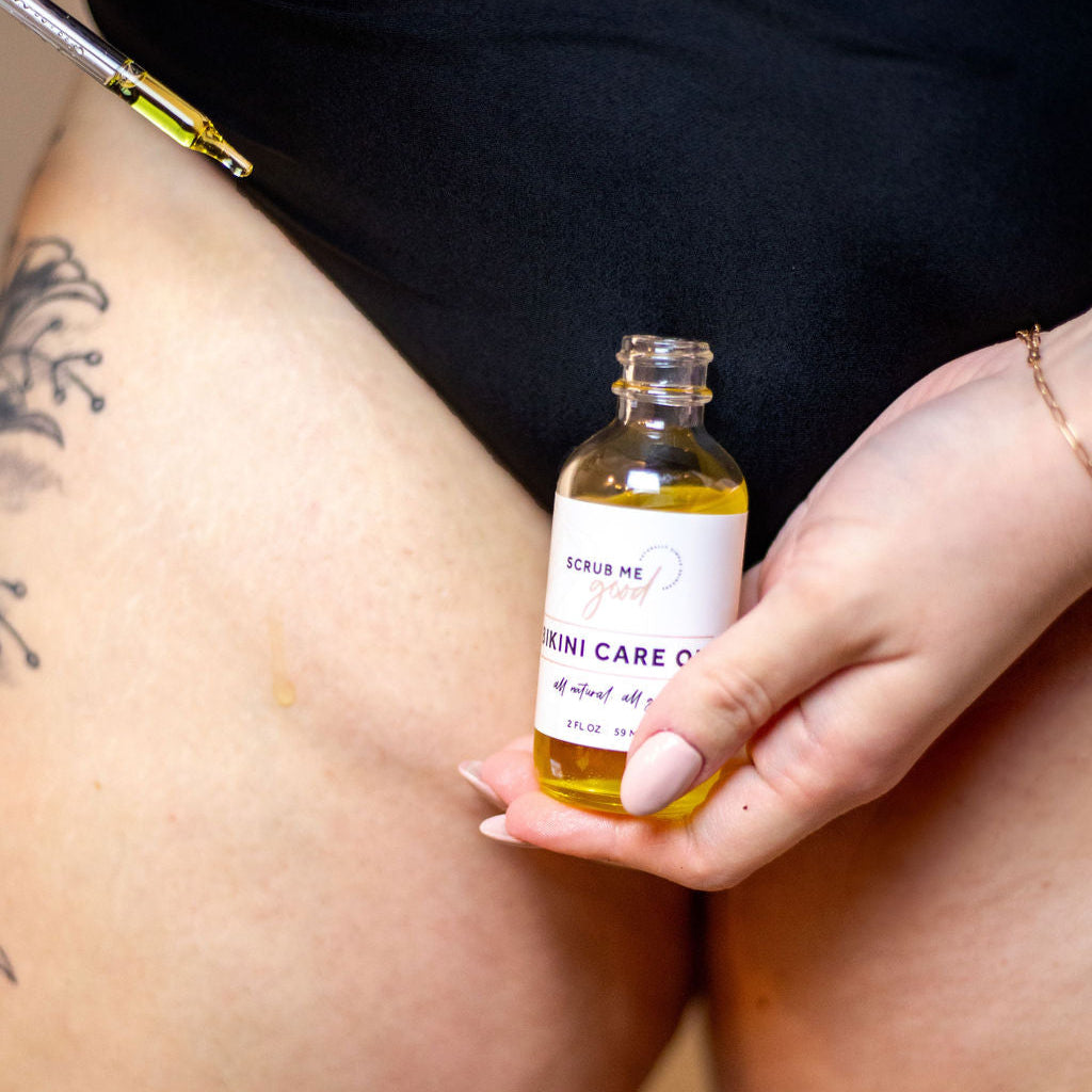 Woman applying Bikini Care Oil by Scrub Me Good with dropper for smooth post-wax skin