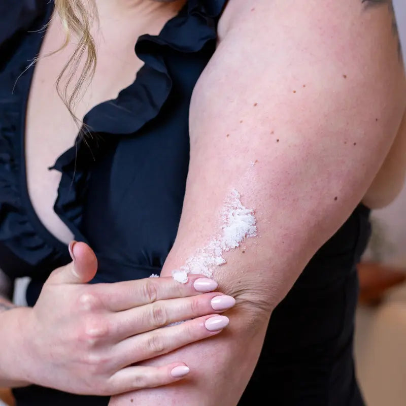 Woman apply scrub me good exfoliating sugar scrub