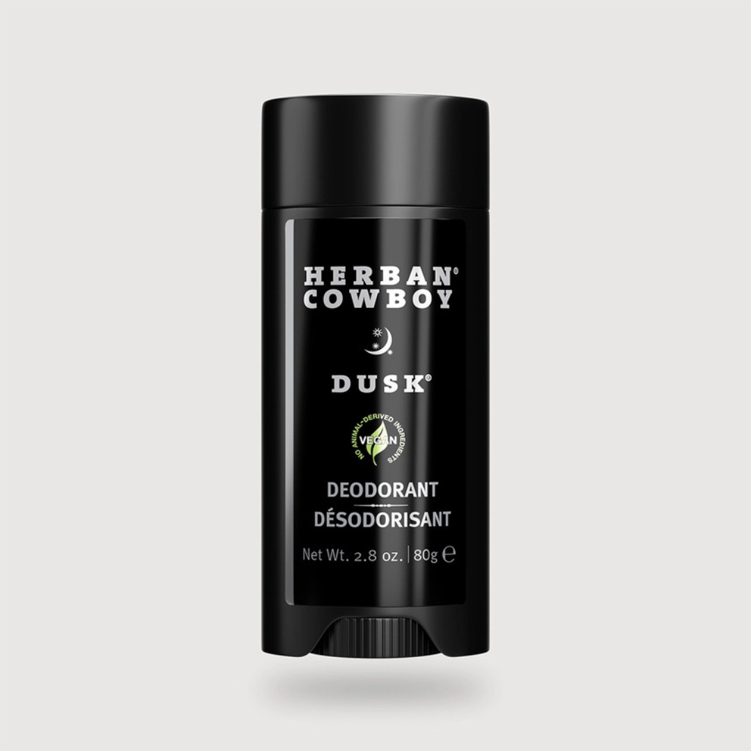 Herban Cowboy Dusk stick deodorant for men with sandalwood, sage, and cedar leaf on a neutral background