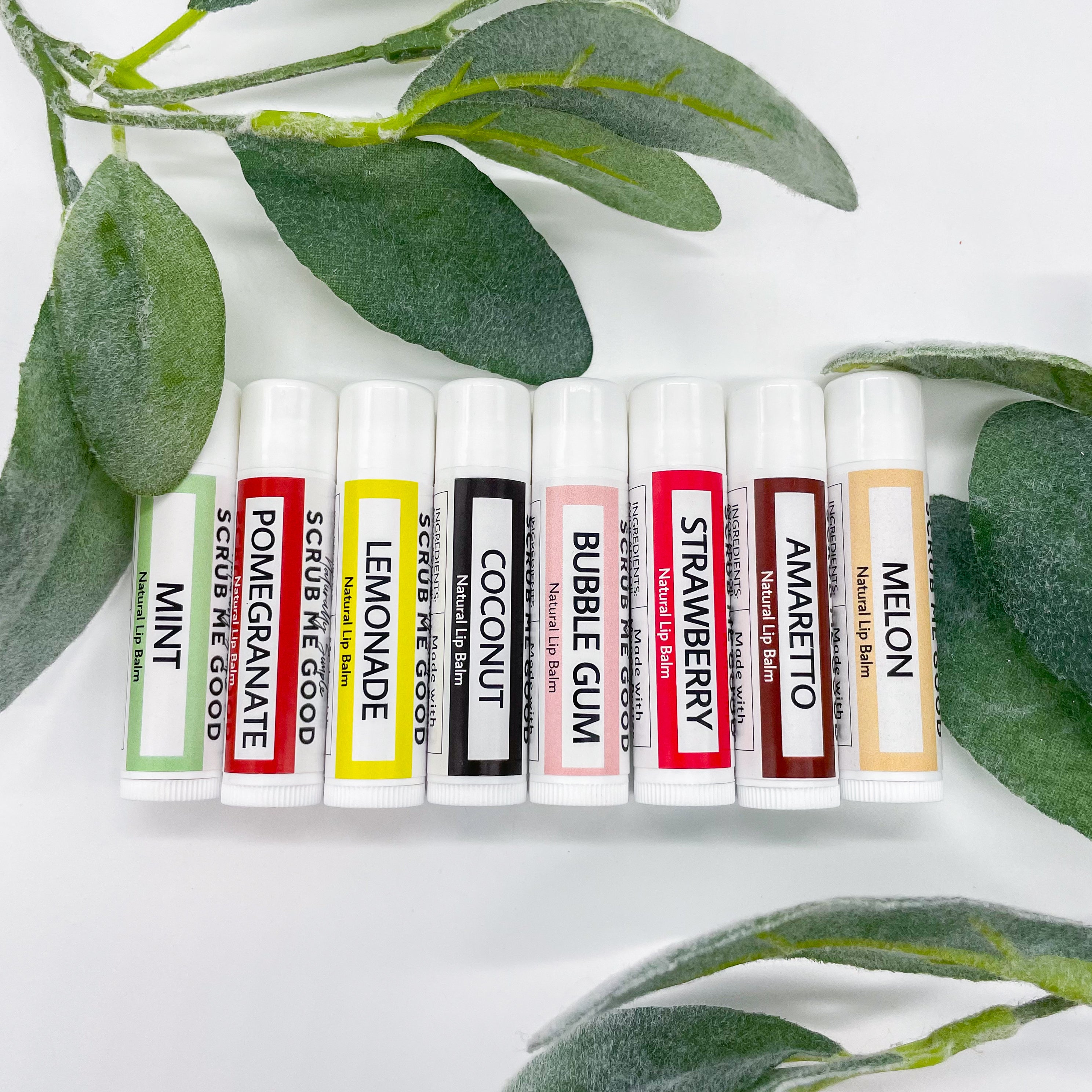 lip balms lined up surrounded by eucalyptus leaves
