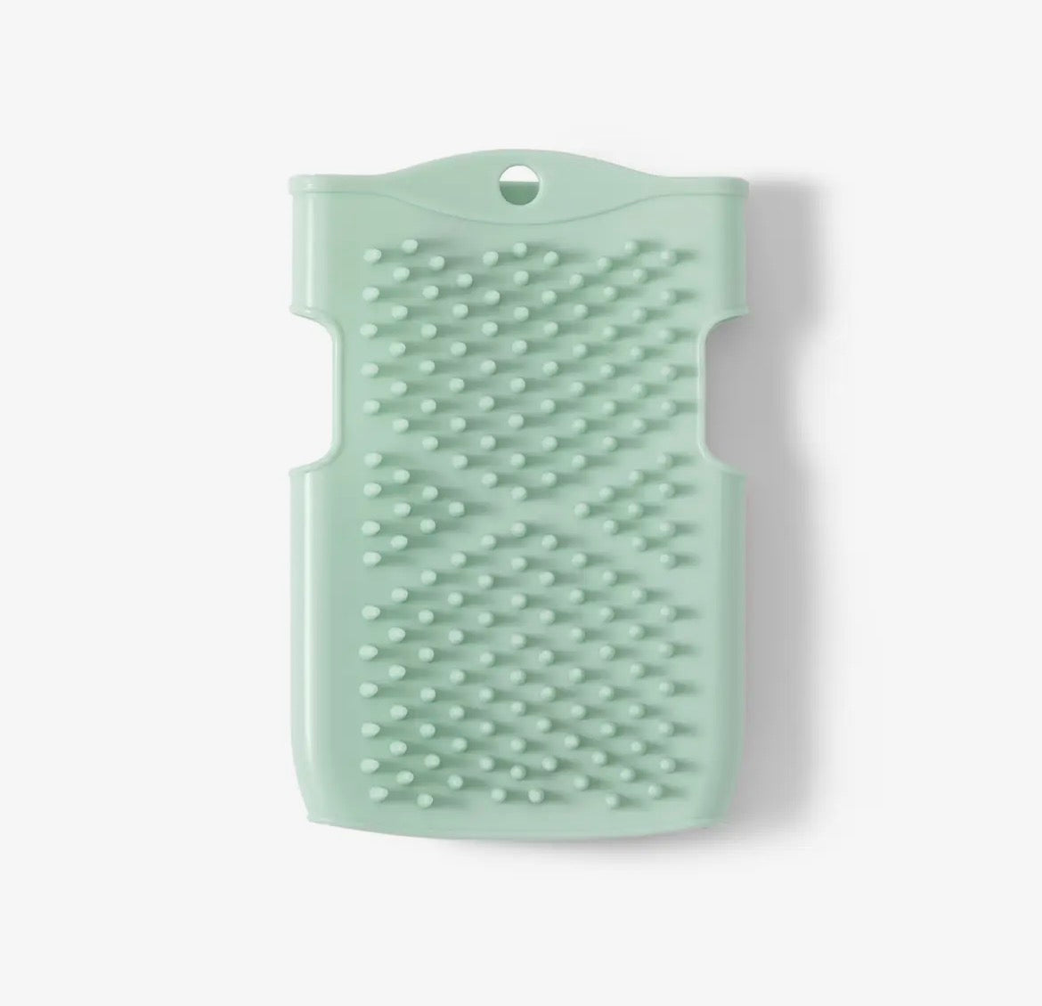 Mint green silicone brush on a white background