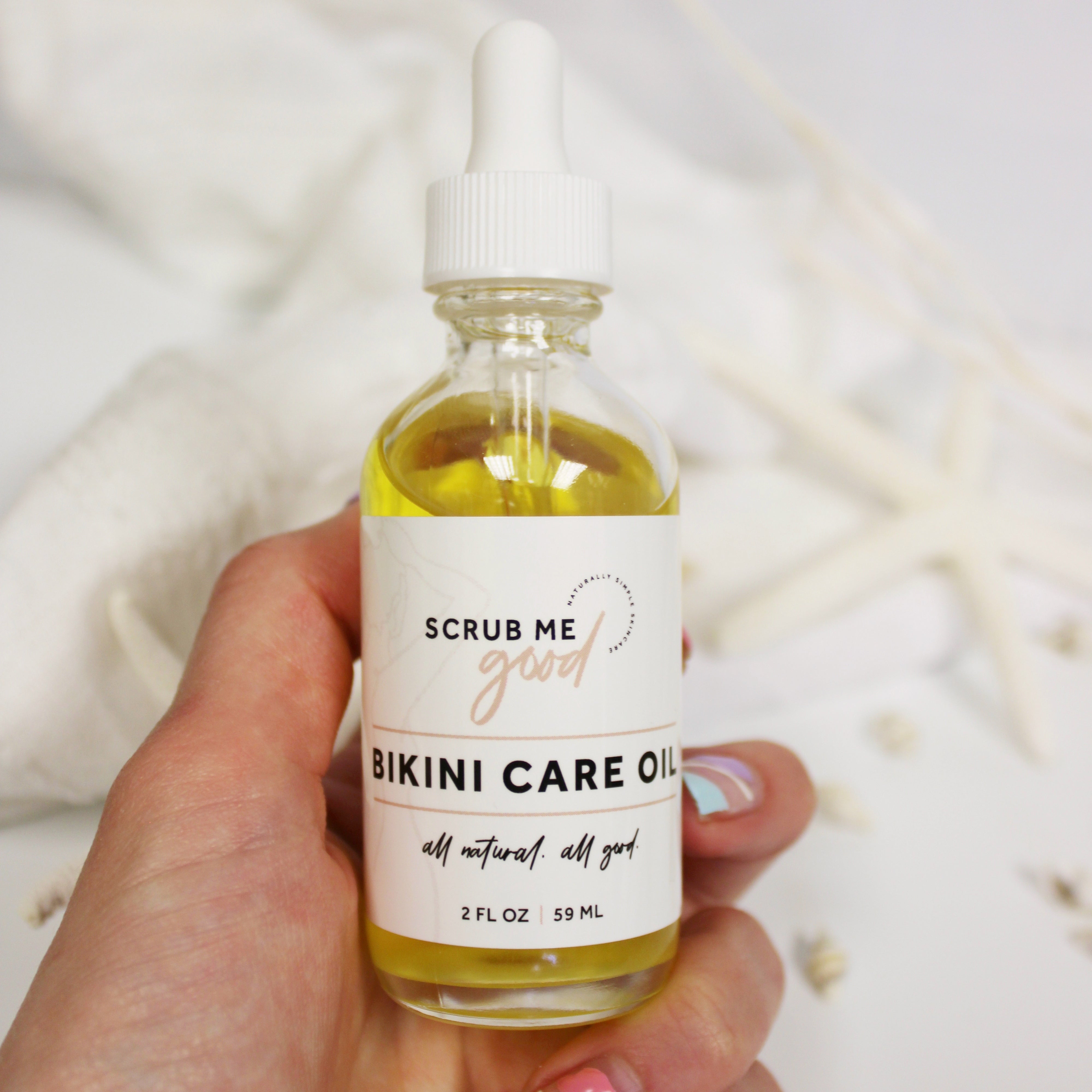 woman holding Bikini Care Oil for ingrown hair prevention by Scrub Me Good