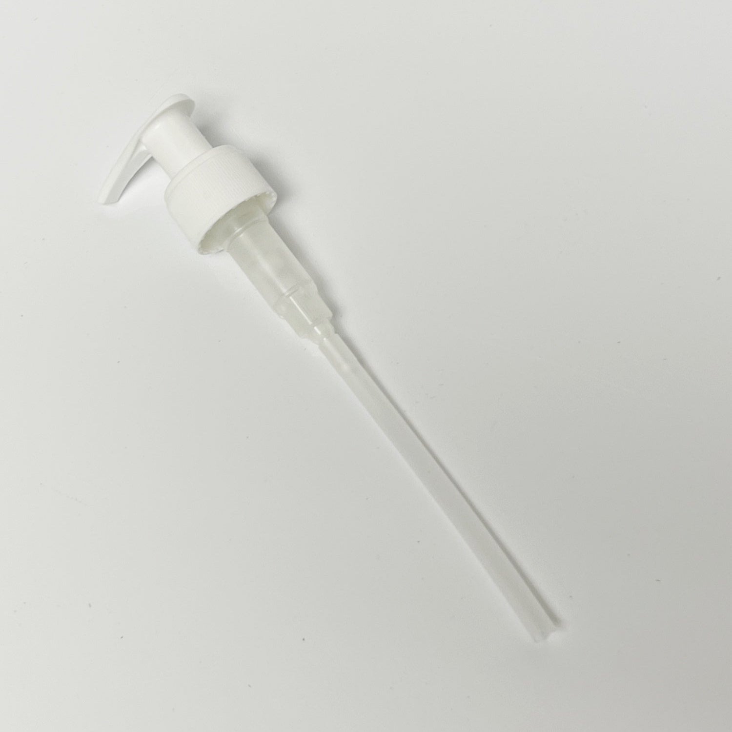 White pump dispenser on a light background